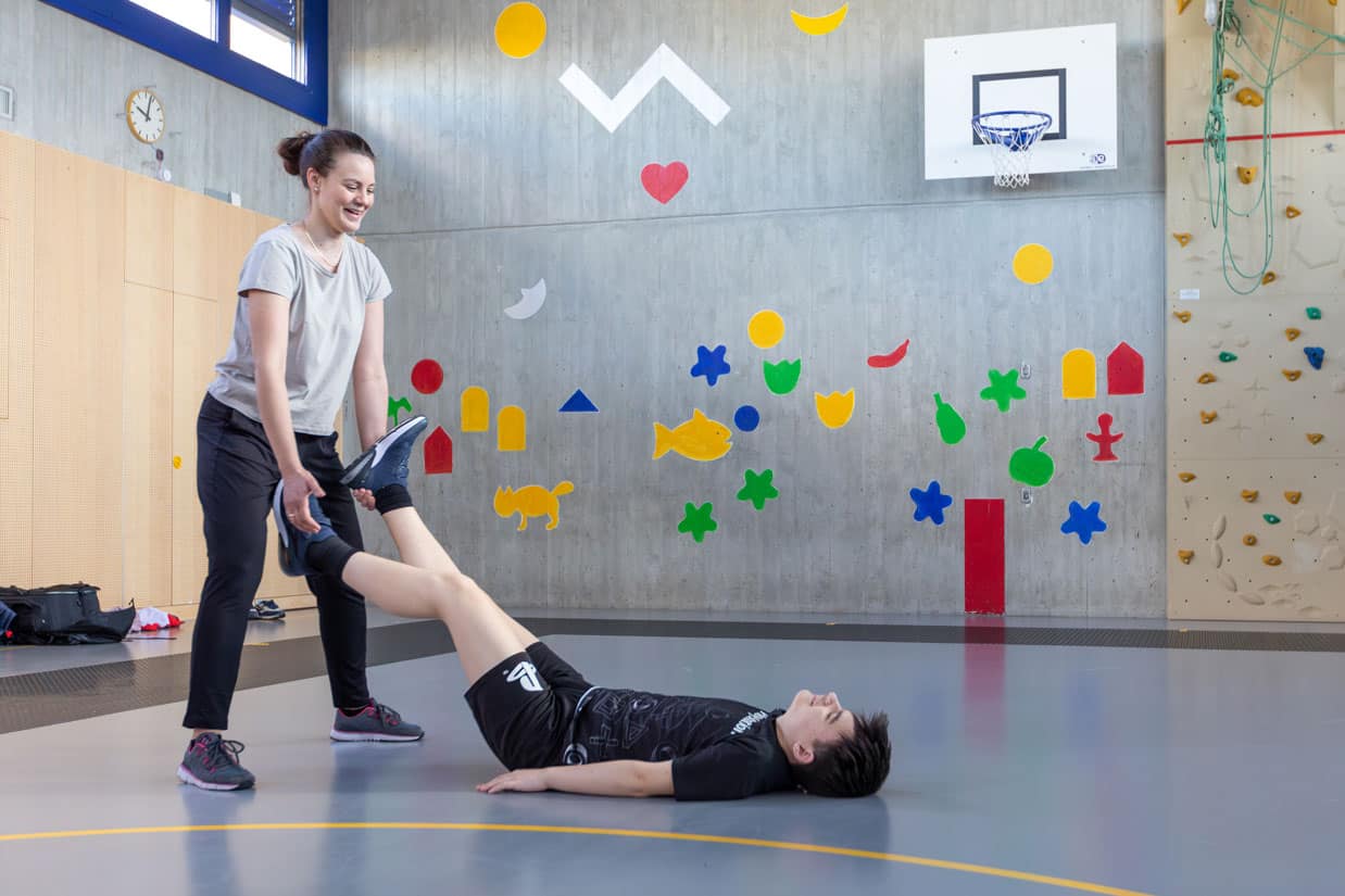 Sehbeeinträchtigter Jugendlicher nimmt an sportlichen Aktivitäten in einer Turnhalle teil. Sehbeeinträchtigter Jugendlicher nimmt an sportlichen Aktivitäten in einer Turnhalle teil.