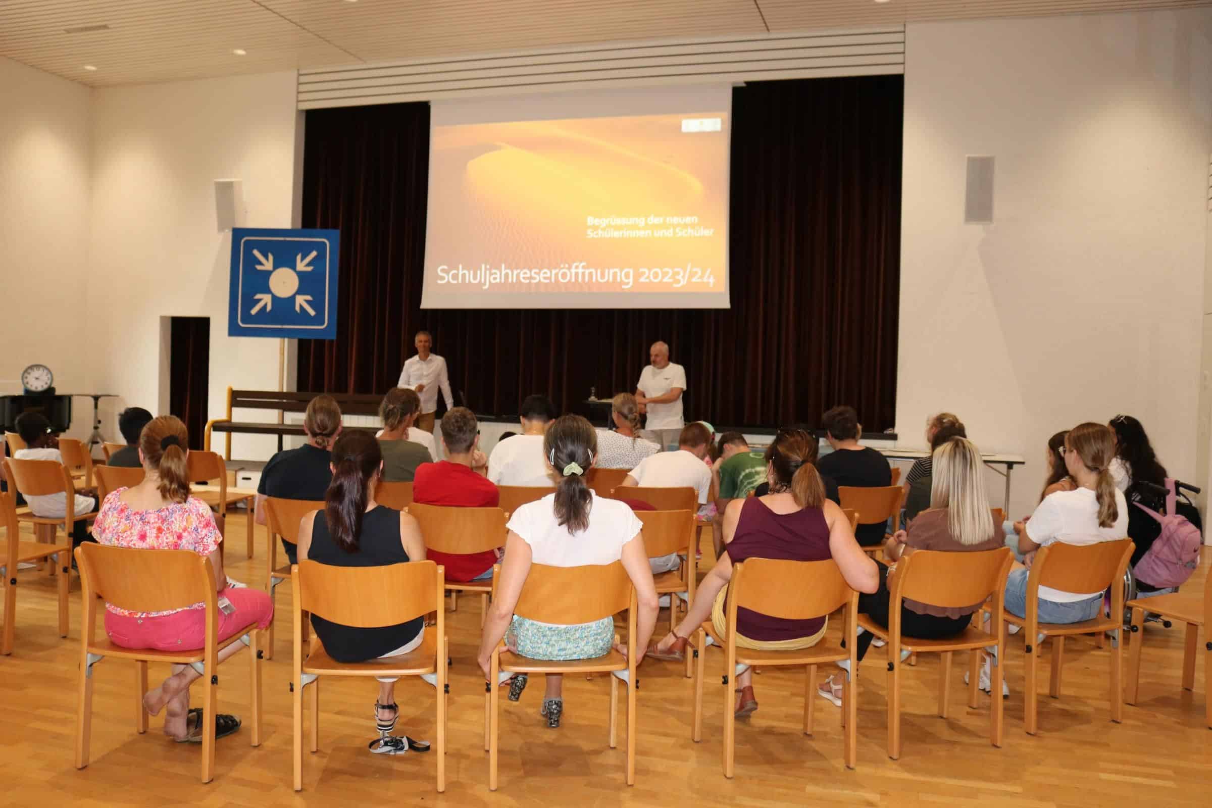 Die neuen Schülerinnen und Schüler sitzen in einem Halbkreis und hören gespannt den Informationen zu. Die neuen Schülerinnen und Schüler sitzen in einem Halbkreis und hören gespannt den Informationen zu.