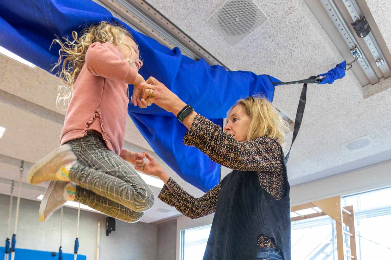 Sehbeeinträchtigtes Mädchen mit zusätzlichen Beeinträchtigungen hüpft vergnügt auf einem Trampolin. Sehbeeinträchtigtes Mädchen mit zusätzlichen Beeinträchtigungen hüpft vergnügt auf einem Trampolin.